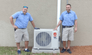 Coastal Climate Experts stand next to a repaired HVAC unit, offering unparalleled commercial heating repair services.