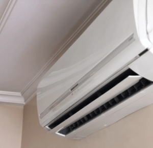 A white ductless mini split AC unit on the wall near the ceiling